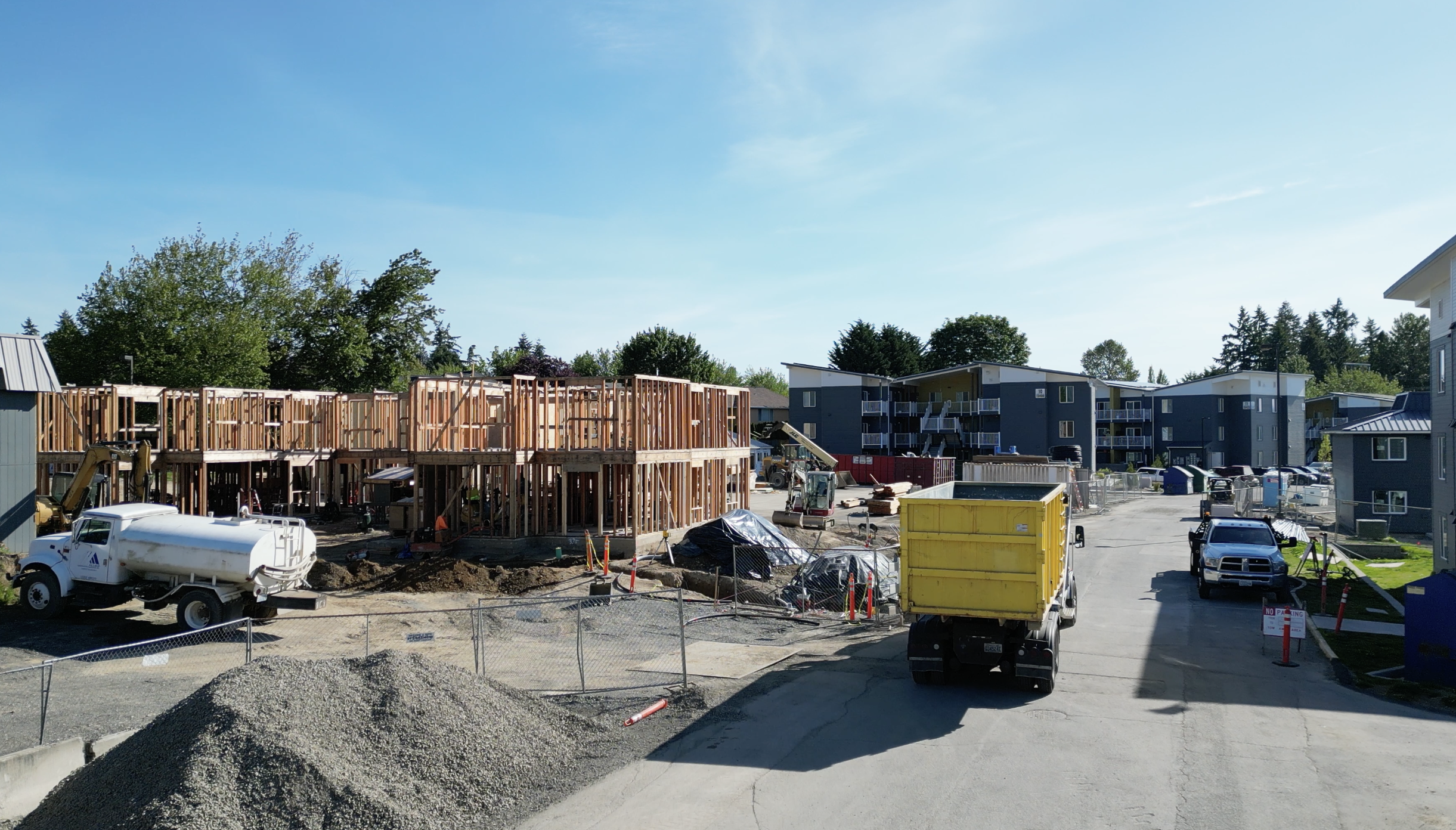 Contractor walking job site with dumpster in background